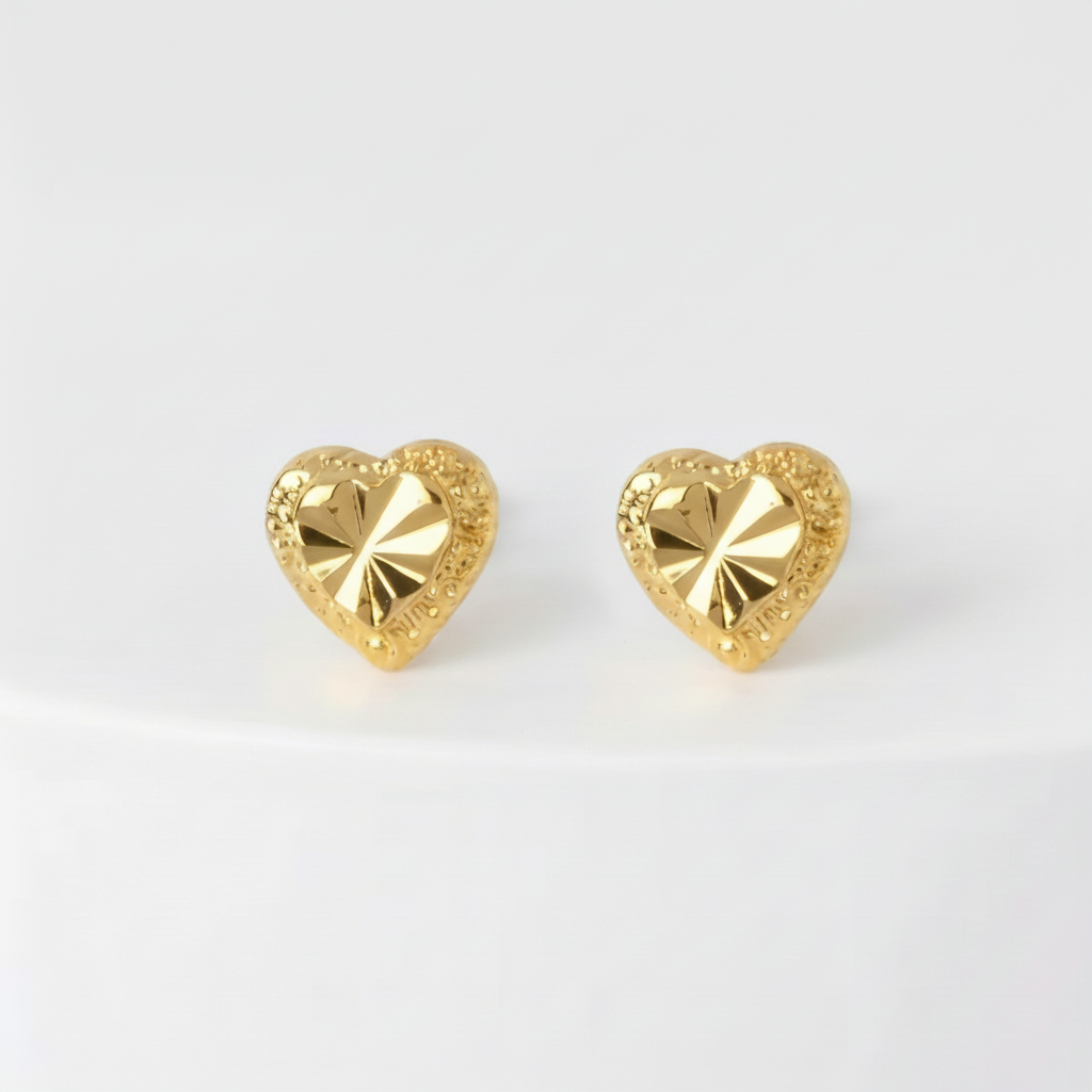 Gold heart-shaped earrings on a white background