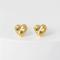 Gold heart-shaped earrings on a white background